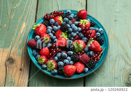 Mix of ripe colorful berries in bowl photography . Blueberry , strawberry , raspberry , blackberry and red currant . Top view 120268922