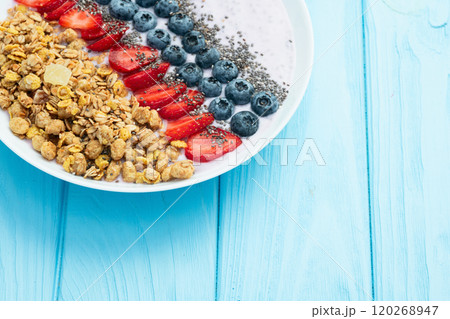 Healthy breakfast . Yogurt with berries ( strawberry , raspberry , blueberry , blackberry ) , granola and chia seeds . Top view Healthy breakfast . Yogurt with berries ( strawberry , raspberry , blueberry , blackberry ) , granola and chia seeds . Top view 120268947
