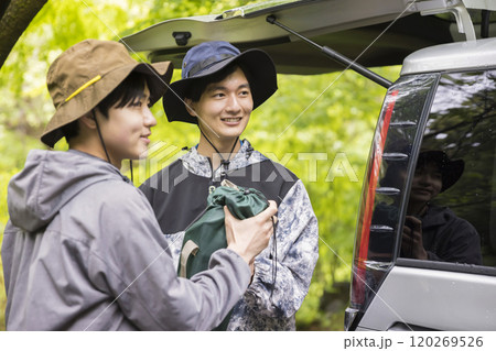 アウトドアイメージ　車からキャンプ道具を運びだす男性 120269526