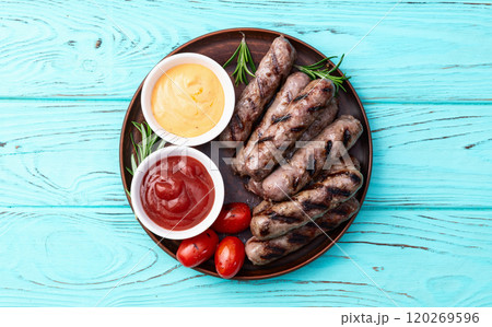 Grilled beef sausages with rosemary sauce and tomatoes photography . Top view 120269596