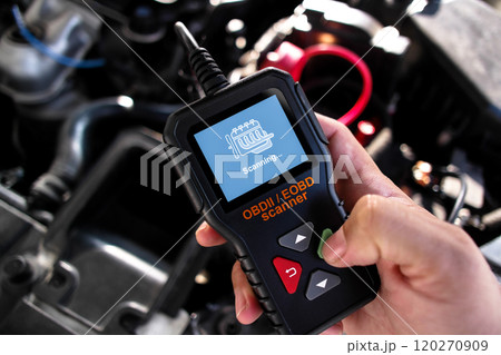 OBDII Scanner in use under the hood by auto mechanic for reading fault code of the car engine system 120270909