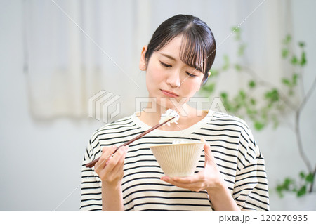 お米を食べる若い女性　食欲不振　まずいご飯 120270935