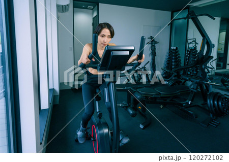 ジムでエアロバイクを漕ぐを女性 120272102