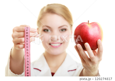Doctor specialist holding fruit apple and measure tape 120274817