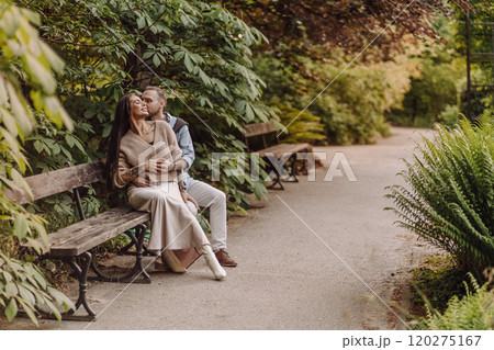 Happy loving couple enjoying their time together in park. Loving couple spending time together. Girl with tattoos. Tattooed woman. Beautiful fashionable couple of lovers on the street. 120275167