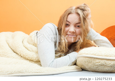 Woman waking up in bed in morning after sleeping 120275233