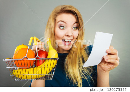 Happy woman holding shopping basket with fruits Happy woman holding shopping basket with fruits 120275535
