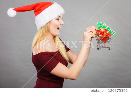 Santa woman holding shopping cart with christmas gifts Santa woman holding shopping cart with christmas gifts 120275543