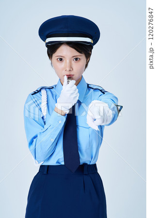 笛を鳴らしながら指さしをする女性警備員 120276847