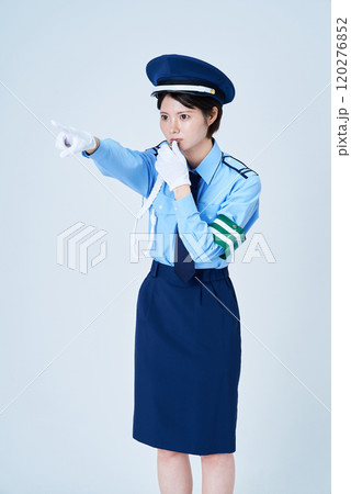 笛を鳴らしながら指さしをする女性警備員 120276852