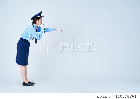 笛を鳴らしながら指さしをする女性警備員 120276861