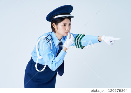 笛を鳴らしながら指さしをする女性警備員 120276864