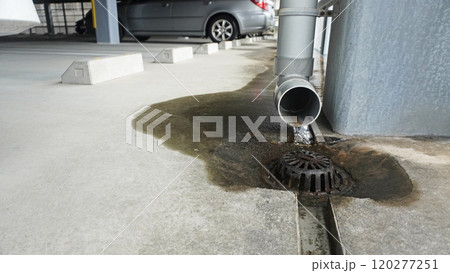 配管から排水された雨水がコンクリートに流れ出す 120277251