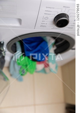 A Washing Machine Engaged in a Spin Cycle Featuring Bright and Colorful Laundry Items A Washing Machine Engaged in a Spin Cycle Featuring Bright and Colorful Laundry Items 120279048