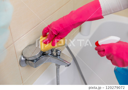 Thoroughly cleaning bathroom fixtures with a sponge and sprays is essential for hygiene Thoroughly cleaning bathroom fixtures with a sponge and sprays is essential for hygiene 120279072