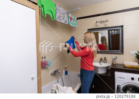 Its Laundry Day in a Bright Bathroom with Clothes Happily Hanging Up to Dry for Freshness Its Laundry Day in a Bright Bathroom with Clothes Happily Hanging Up to Dry for Freshness 120279188