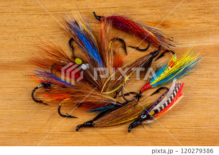 Pile of Traditional Salmon Fishing Flies on a Wooden Surface 120279386