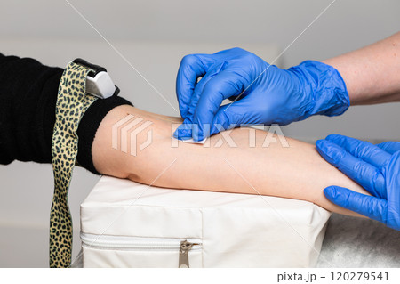 Nurse preparing patients arm for blood draw 120279541