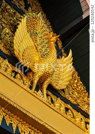 Golden sculpture of Peacock at the facade of main hall in buddhist temple. 120280542