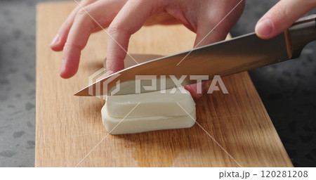 Closeup man slicing fresh mozzarella on oak board Closeup man slicing fresh mozzarella on oak board 120281208
