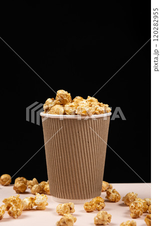 Sweet caramelized popcorn in a bucket. Black background. Place for text 120282955
