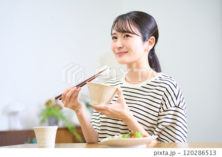 お米を食べる若い女性 120286513