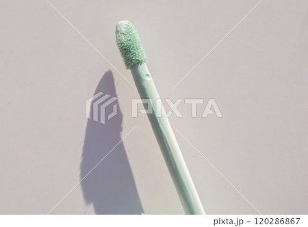 Close-up of a brush of green concealer for correcting skin imperfections, on a white background Close-up of a brush of green concealer for correcting skin imperfections, on a white background 120286867