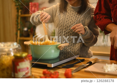 Young married beautiful couple in sweaters preparing dinner on Christmas Day in kitchen 120288178