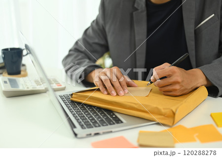 Close up male employee writing tasks on adhesive note 120288278