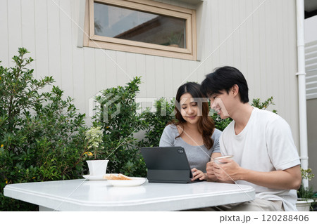 Happy asian couple sharing moments and using digital tablet in garden 120288406