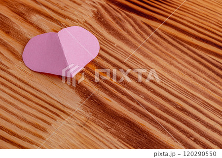 Pink heart cut out of paper on a wooden light background 120290550