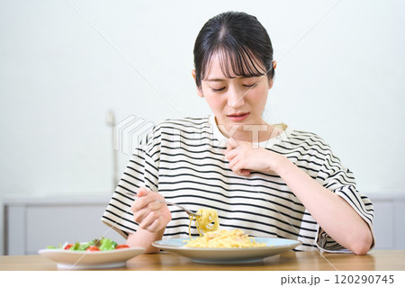 パスタを食べる若い女性　食欲不振　悩みごと　 120290745
