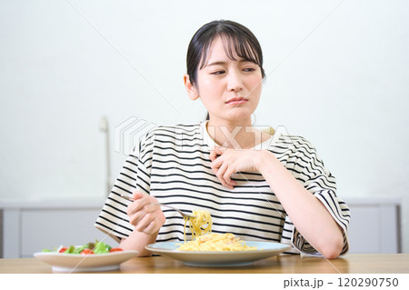 パスタを食べる若い女性　食欲不振　悩みごと　 120290750