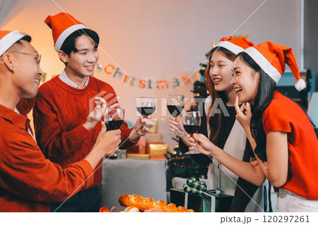 Group of young Asian man and women as friends having fun at a New Year's celebration, holding gift boxes standing by Christmas tree decoration, midnight countdown Party at home with holiday season. Group of young Asian man and women as friends having fun at a New Year's celebration, holding gift boxes standing by Christmas tree decoration, midnight countdown Party at home with holiday season. 120297261