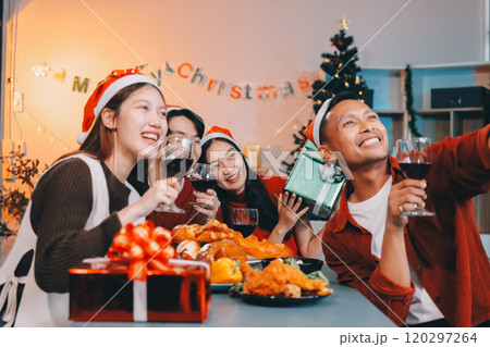 Group of young Asian man and women as friends having fun at a New Year's celebration, holding gift boxes standing by Christmas tree decoration, midnight countdown Party at home with holiday season. Group of young Asian man and women as friends having fun at a New Year's celebration, holding gift boxes standing by Christmas tree decoration, midnight countdown Party at home with holiday season. 120297264