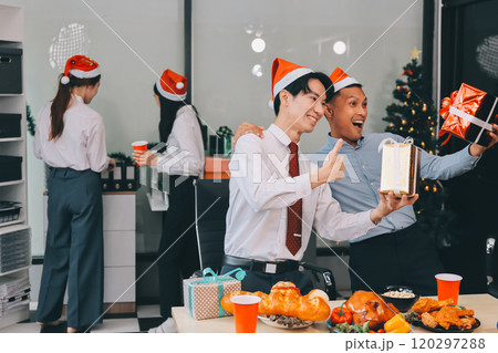 full length view of a group of business team wearing red Santa hat and exchange gift box together in the office for Christmas. full length view of a group of business team wearing red Santa hat and exchange gift box together in the office for Christmas. 120297288