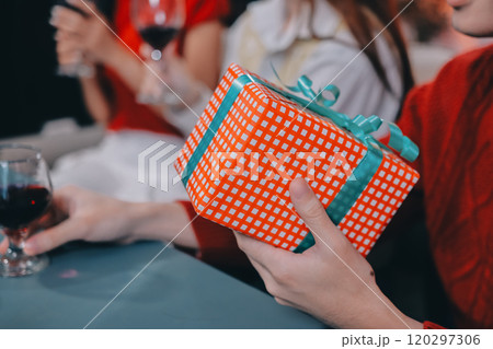Friends opening Christmas gifts in living room Friends opening Christmas gifts in living room 120297306