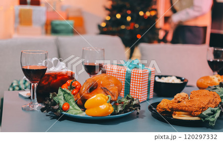 Group of young Asian man and women as friends having fun at a New Year's celebration, holding gift boxes standing by Christmas tree decoration, midnight countdown Party at home with holiday season. 120297332