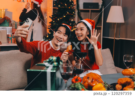 Group of young Asian man and women as friends having fun at a New Year's celebration, holding gift boxes standing by Christmas tree decoration, midnight countdown Party at home with holiday season. Group of young Asian man and women as friends having fun at a New Year's celebration, holding gift boxes standing by Christmas tree decoration, midnight countdown Party at home with holiday season. 120297359
