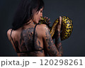 Image of the woman from back holding anaconda 120298261