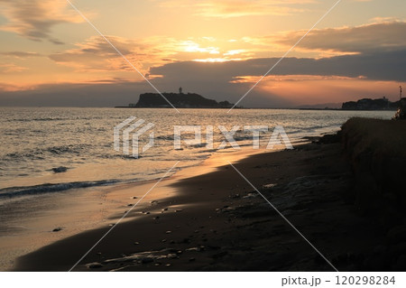 鎌倉・七里ヶ浜海岸から見るオレンジ色になる夕陽と江ノ島のある風景 鎌倉・七里ヶ浜海岸から見るオレンジ色になる夕陽と江ノ島のある風景 120298284
