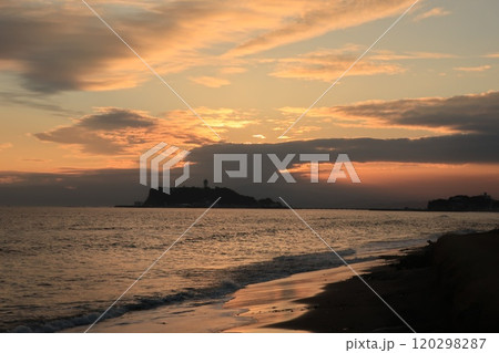鎌倉・七里ヶ浜海岸から見るオレンジ色になる夕陽と江ノ島のある風景 120298287