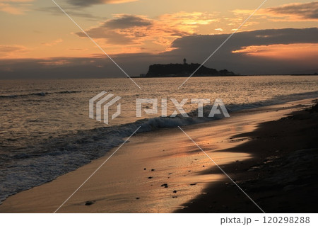 鎌倉・七里ヶ浜海岸から見るオレンジ色になる夕陽と江ノ島のある風景 120298288