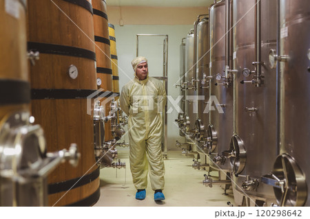 Winemaker working in modern large winery factory liquor drink industry quality. Staff inspecting wine in modern wine factory. Winery manufacturing quality control. Alcohol and wine winemaking process 120298642