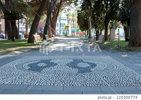 Park with pine trees and pebble path in resort town of Sestri Levante, Italy, 2024. Nature and recreation. Traditional buildings. Sunny day and clear sky. Ecologically clean nature. Park with pine trees and pebble path in resort town of Sestri Levante, Italy, 2024. Nature and recreation. Traditional buildings. Sunny day and clear sky. Ecologically clean nature. 120300774