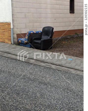 Items and old furniture on street outside house moving day or getting rid of junk and household storage concept. Old damaged furniture extruded on a pile of unnecessary things on the pavement 120302135