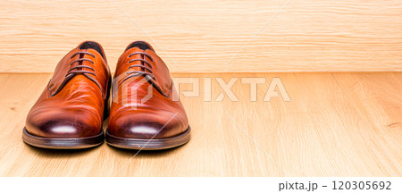 Elegant Brown Leather Shoes on Wood Background 120305692