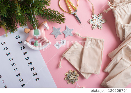 Christmas Advent calendar with gift velvet bags on a light pink background. 120306794