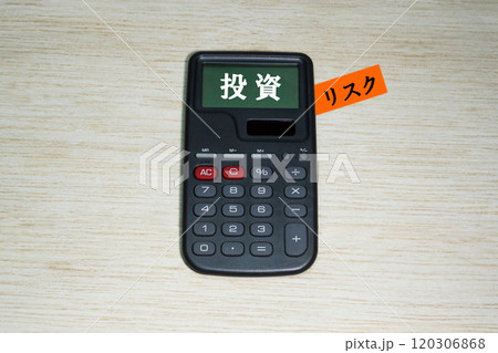 机の上の電卓に書かれた「投資」「リスク」という文字 机の上の電卓に書かれた「投資」「リスク」という文字 120306868