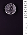 Faceted sphere, sparkling crystal on dark, black background. Large glass with light refraction, stone backdrop. Empty space for inscriptions 120308895